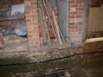 Installing a ring main before the floor was laid.