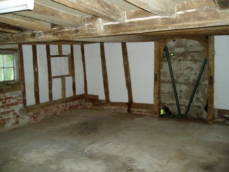 The living room before work started, showing the blocked doorway and frame and the concrete floor 
